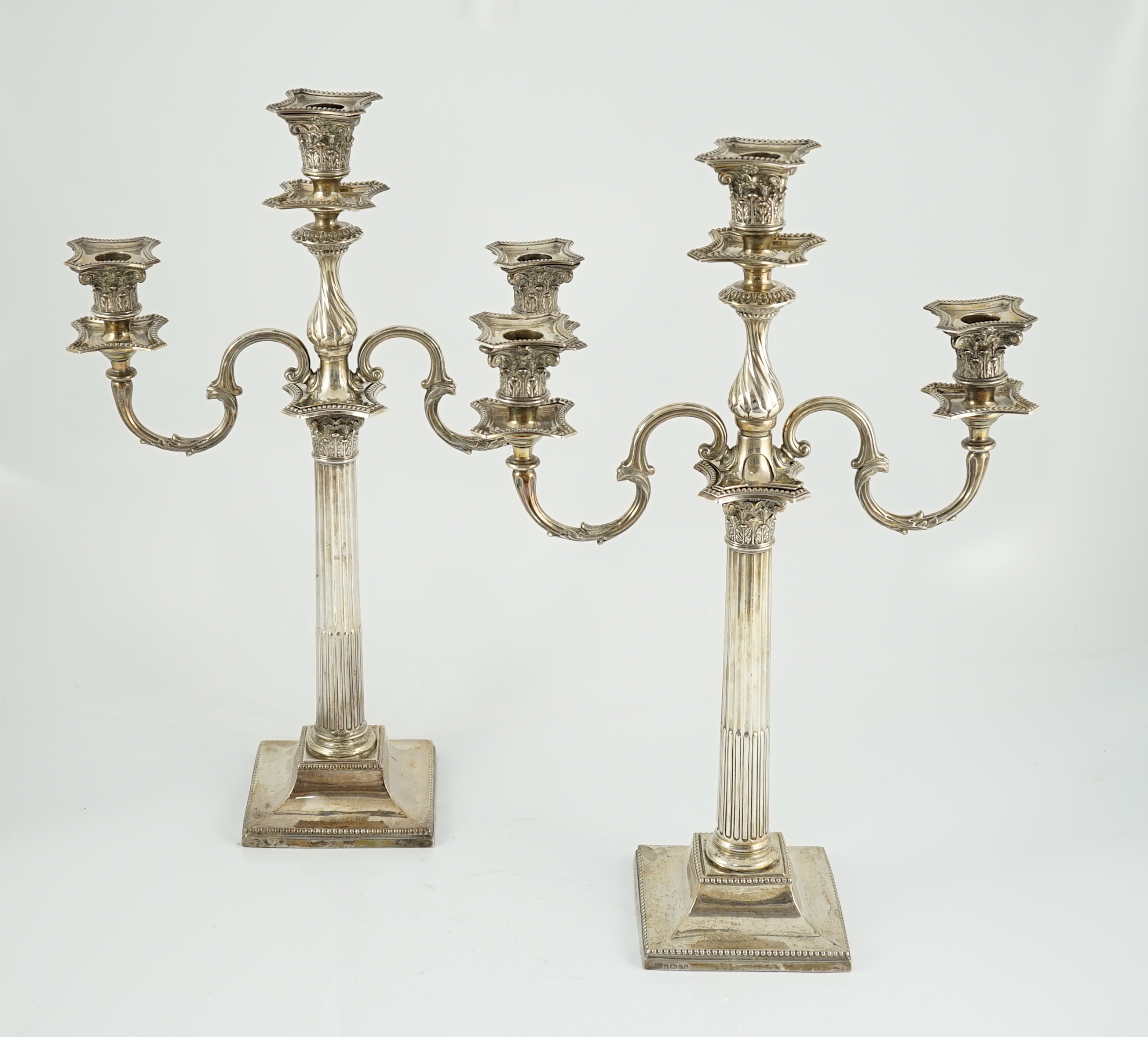 A matched pair of late 19th/early 20th century silver two branch, three light candelabrum